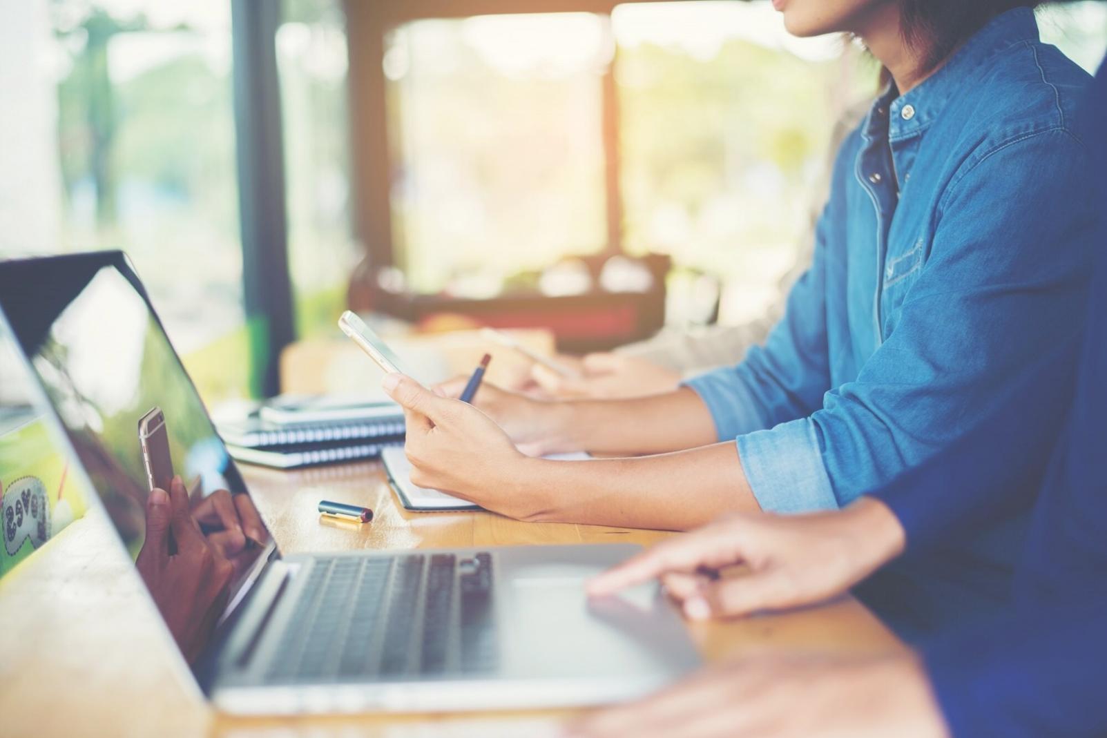 Persona revisando documentos financieros en escritorio organizado